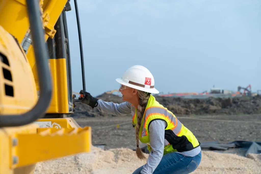Heavy Equipment Operator inspects the Hybrid excavator.